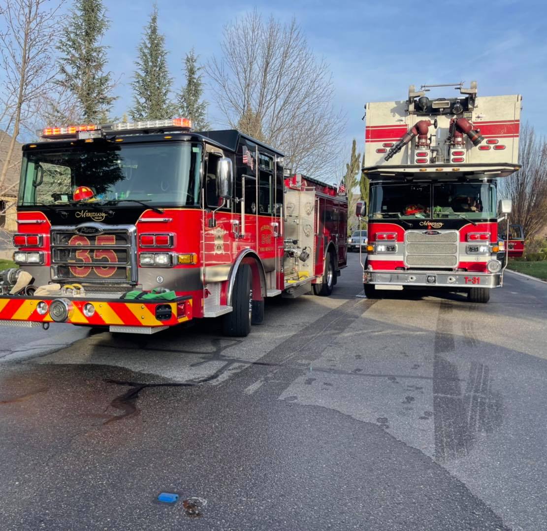 Two Fire Tucks on a city street.