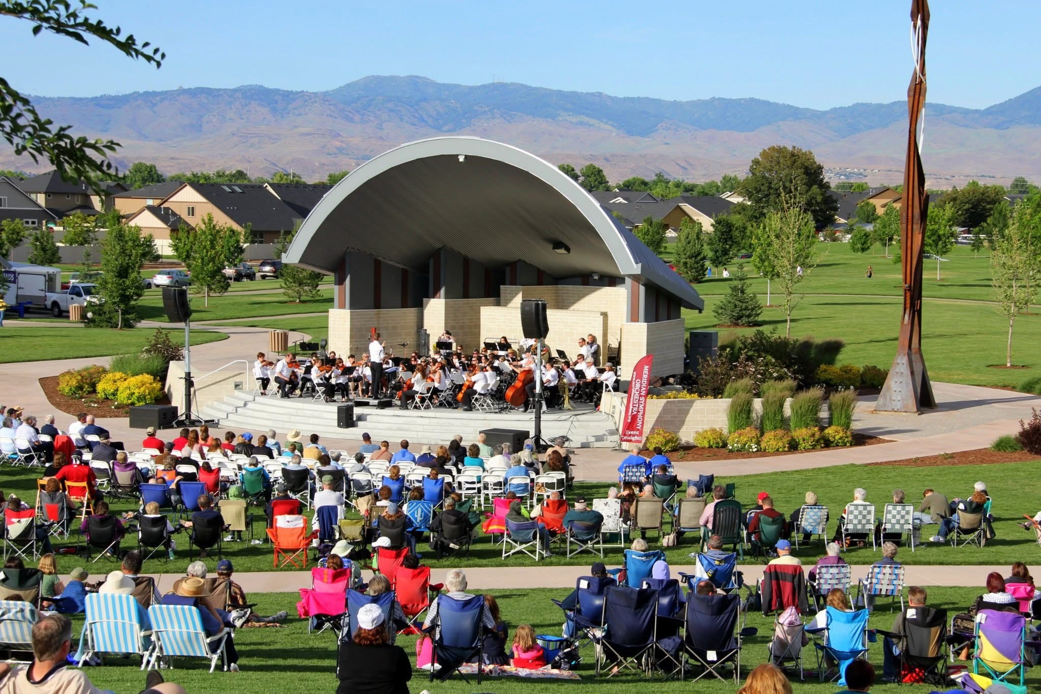 Kleiner Park bandshell with people watching in lawn chairs listening to classical music.